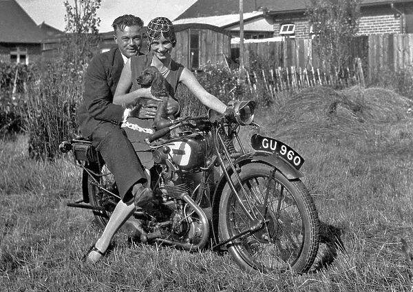 Couple on a motorbike with a dog