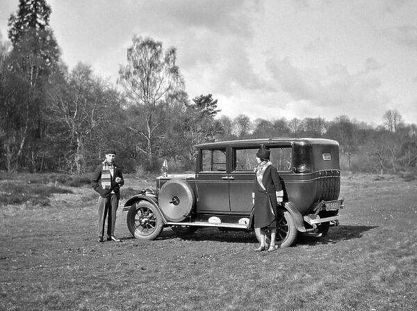 Couple relaxing by their car in a field
