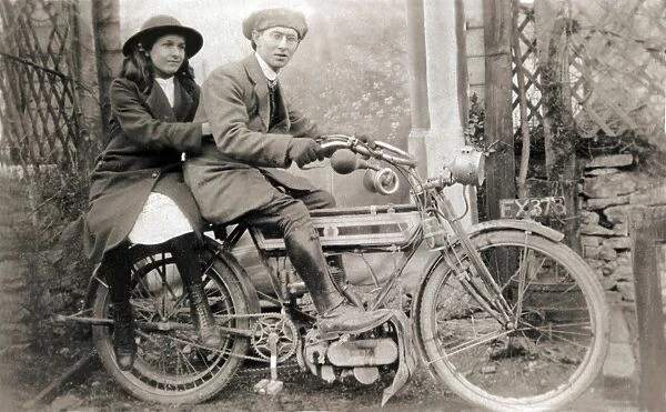 Couple sitting on 1905 Triumph motorcycle