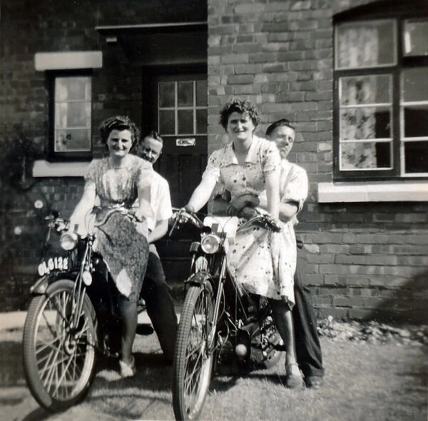Two couples on two 1930s  /  40s Velocette motorcycles outside h
