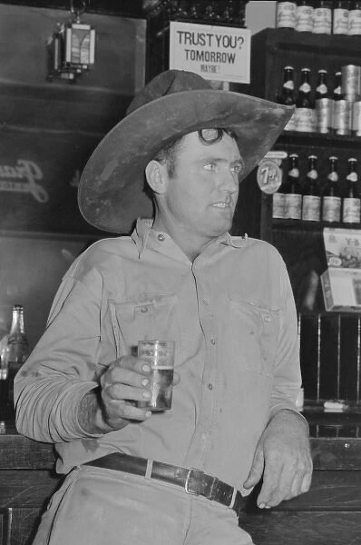 Cowboy drinking beer in beer parlor, Alpine, Texas