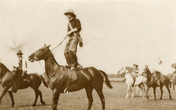 Cowboy riding on a horse, standing on its back