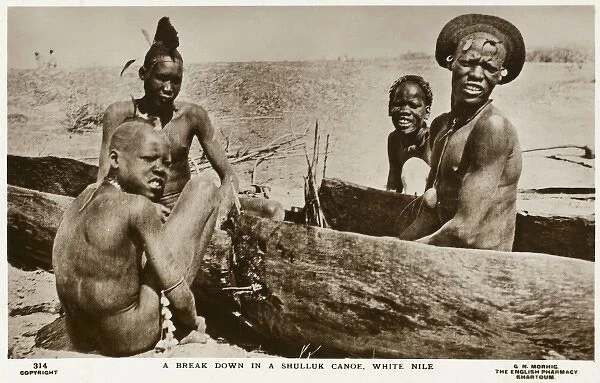 Dinka Tribesmen in carved-out canoe