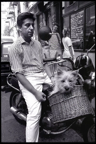Dog riding in a basket on a scooter, Paris, France