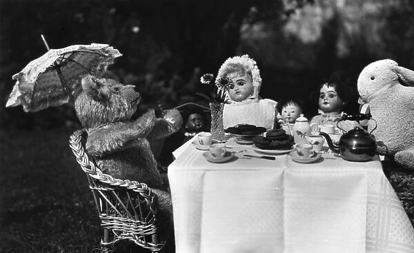 Dolls, teddy and rabbit enjoying a tea party