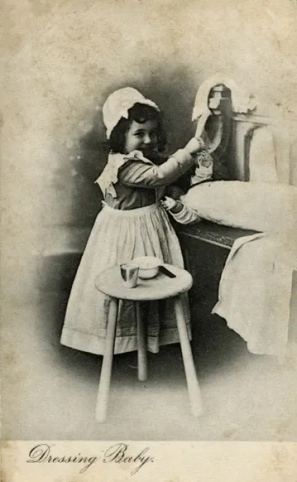 Framed Print : Dressing Baby -- little girl with her doll Framed Print : Dressing Baby -- little girl with her doll