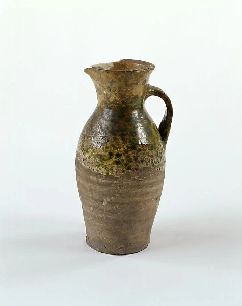 Jug. Earthenware jug with green glaze decoration, a handle