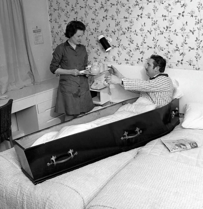 Framed Print : Eddie Merton, superstitious stuntman, who always slept in a coffin on the night before a dangerous stunt. Seen here sitting up in the coffin in his hotel bedroom for his morning cup of tea. Date: 1971 Framed Print : Eddie Merton, superstitious stuntman, who always slept in a coffin on the night before a dangerous stunt. Seen here sitting up in the coffin in his hotel bedroom for his morning cup of tea. Date: 1971