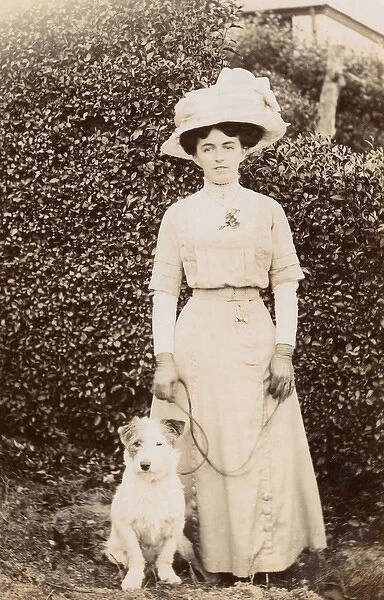 Edwardian woman with a terrier in a garden