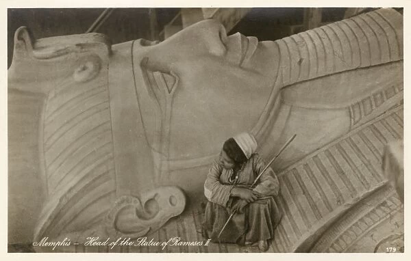Egyptian boy sitting on the head of Rameses II