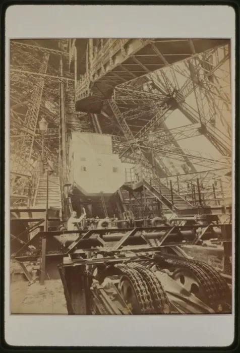 Framed Print : Eiffel Tower machinery with man beside wheel that raises ele Framed Print : Eiffel Tower machinery with man beside wheel that raises ele
