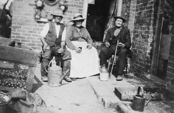 Three elderly people sitting outside their home