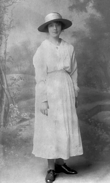 Elegant woman in long white dress and wide-brimmed hat