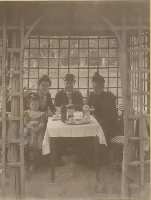 Framed Print : A family, three adults and a little girl, sitting in a rustic Framed Print : A family, three adults and a little girl, sitting in a rustic
