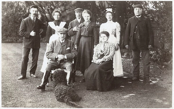 Family group with black poodle in a garden