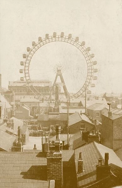 A ferris wheel viewed across the rooftops