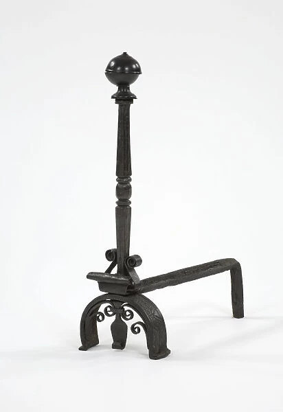 Fire dog. One of a pair of wrought iron fire dogs with turned brass finials, arched legs