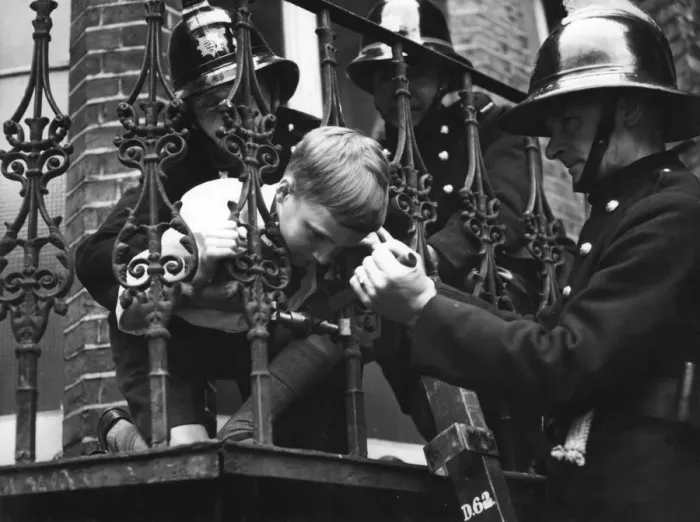 Framed Print : Firefighter using railing expander to release boy Framed Print : Firefighter using railing expander to release boy