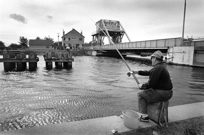 Framed Print : A fisherman sits on the towpath of the Caen Canal