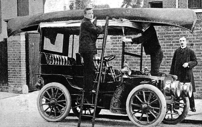 Framed Print : Fixing a canoe to the top of a veteran car, early 1900s Framed Print : Fixing a canoe to the top of a veteran car, early 1900s