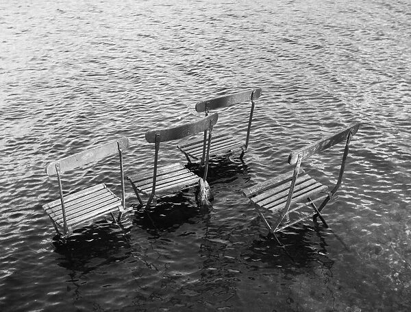 Flooded riverbank with chairs