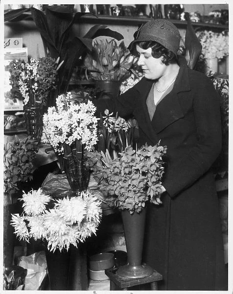 Florist 1930S. A florist arranges vases of freshly cut flowers in her shop