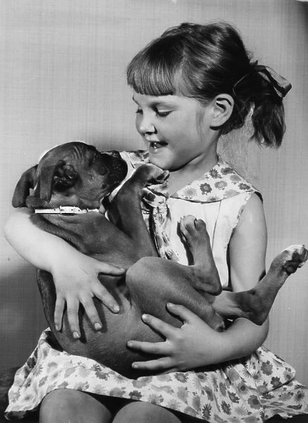 Girl cradling a puppy on her lap