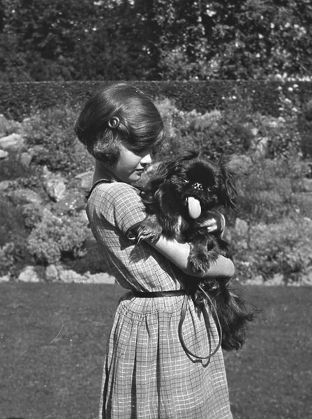 Girl holding a dog in a garden