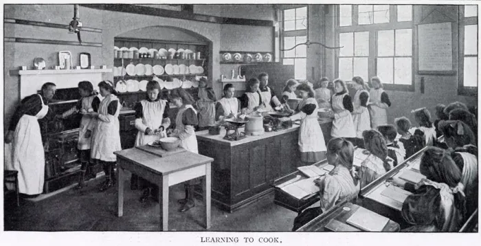 Framed Print : Girls in a cookery lesson, learning to cook tarts and a joint of beef which a group of Framed Print : Girls in a cookery lesson, learning to cook tarts and a joint of beef which a group of