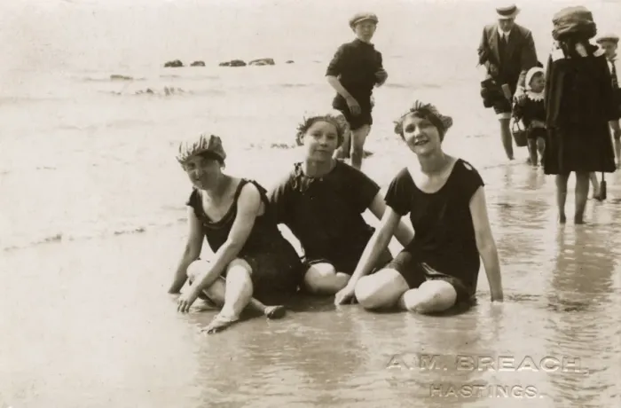 Framed Print : Three girls sitting in the surf at Hastings, Kent