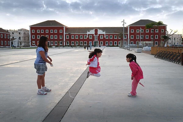 Three girls with skipping rope - plaza, Es Castell, Menorca
