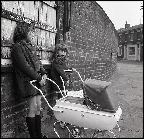 Girls with toy pram in the street