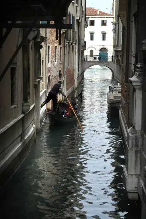 Framed Print : Gondolier fends off boat from a wall with his foot, Venice Framed Print : Gondolier fends off boat from a wall with his foot, Venice