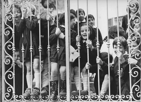 Group of children looking through school gates