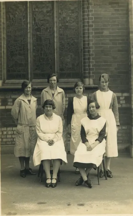 Framed Print : Group of six women, wearing aprons or overalls. They look as if they are staff at a Framed Print : Group of six women, wearing aprons or overalls. They look as if they are staff at a