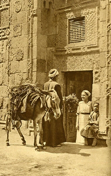 Herb seller in street, chatting to a customer, Egypt