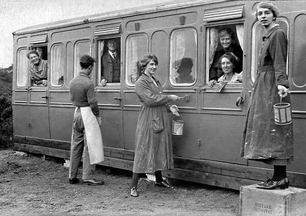 Holidaymakers painting a railway carriage