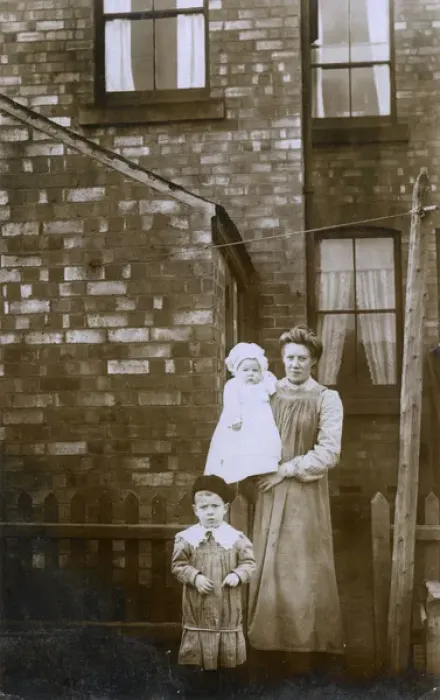 Framed Print : Housewife in the backyard of her terraced home with children Framed Print : Housewife in the backyard of her terraced home with children