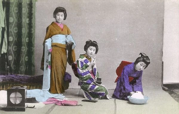 Japanese Geisha attend to dressing, washing and make-up