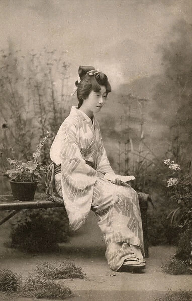 Japanese Geisha seated on a bench