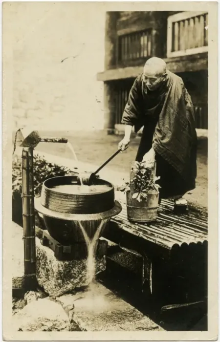Framed Print : A Japanese man watering his flowers from a water pump Framed Print : A Japanese man watering his flowers from a water pump