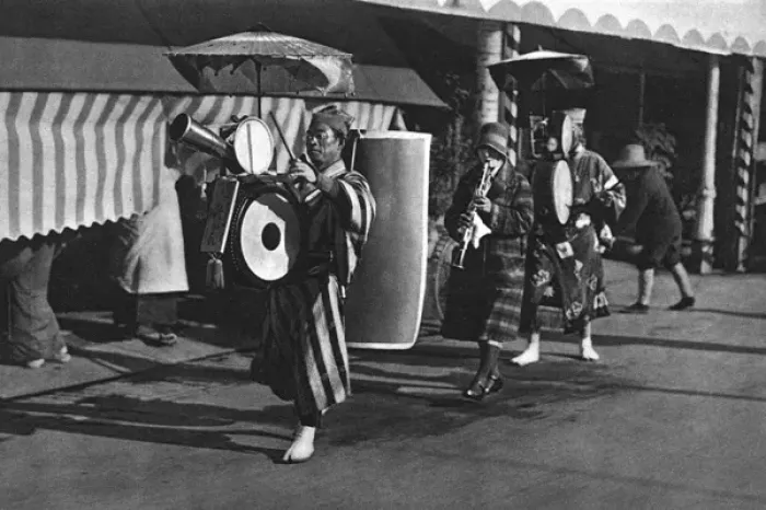 Framed Print : Three Japanese musicians play and walk down a street