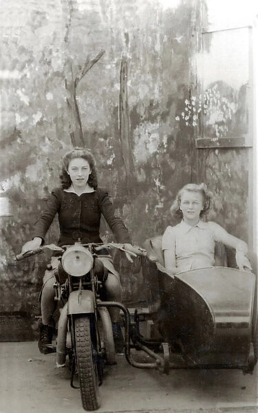 Two ladies in studio on a 1931  /  2 Raleigh motorcycle