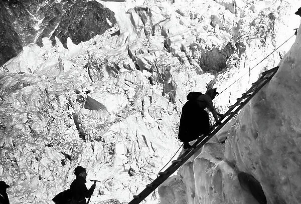 Lady climber crossing a crevasse in the Alps