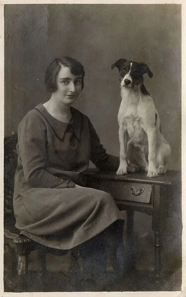 A lady and her dog pose for a studio portrait