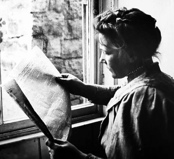 Lady reading newspaper, early 1900s