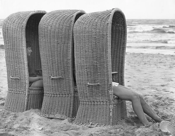 Three large woven beach chairs at the seaside