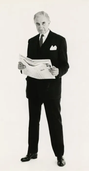 Framed Print : Full length portrait of a mature man posing in a suit, holding a newspaper Framed Print : Full length portrait of a mature man posing in a suit, holding a newspaper