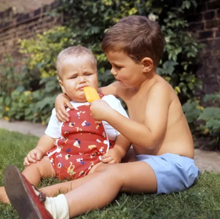 Framed Print : Little boy and baby in garden with ice lolly Framed Print : Little boy and baby in garden with ice lolly