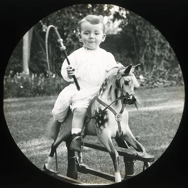 Little boy on a rocking horse with toy whip